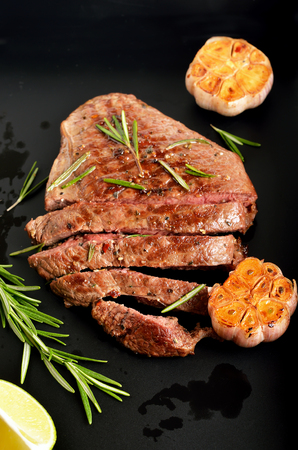 Juicy steak medium rare beef with spices over dark background, close up viewの写真素材