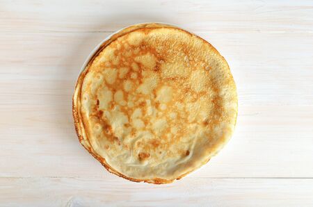 Stack of pancakes on a white wooden surface. Top view. Flat layの写真素材
