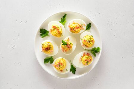 Deviled stuffed eggs with egg yolk, bacon, mustard and parsley. Healthy diet food for breakfast. Top...