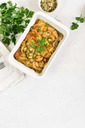 Stewed chicken breast with creamy mushroom sauce on white stone background with copy space. Top...