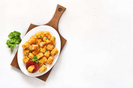 Homemade crispy fried chicken nuggets on plate and tomatoes sauce over light  background with copy space. Top view, flat layの写真素材