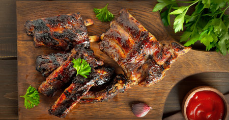 Grilled pork ribs over wooden background. Top view, flat lay