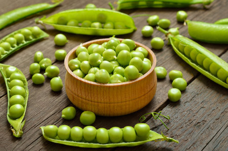 Green peas in wooden bowlの写真素材