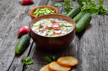 Homemade summer yoghurt cold soup with radish, cucumber, and dill on wooden table. Okroshkaの写真素材