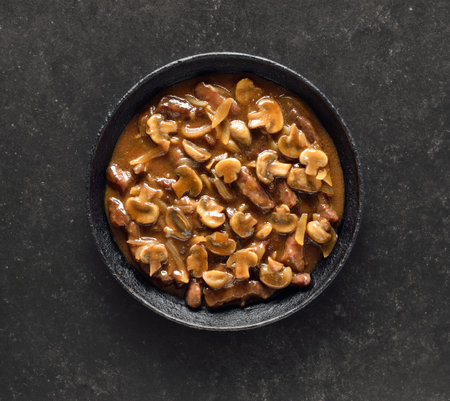 Beef stroganoff with mushrooms over black background. Top view, flat layの写真素材