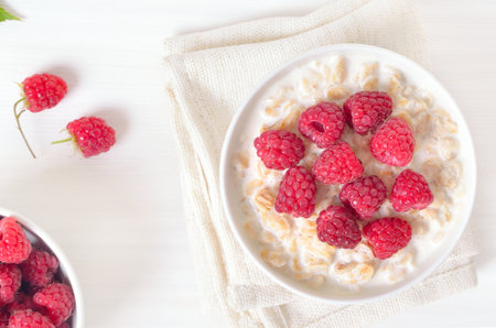 Oatmeal porridge with raspberries in bowl. Top view, flat layの写真素材