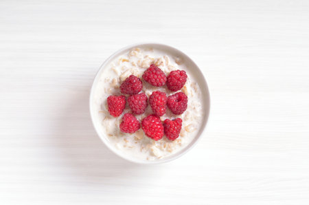 Oatmeal porridge with raspberries in bowl. Top view, flat layの写真素材