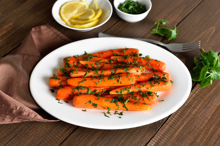 Roasted carrots with green herbs on white plateの写真素材