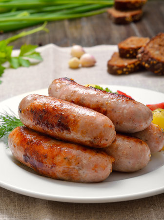 Appetizing barbecue sausages on white plateの写真素材