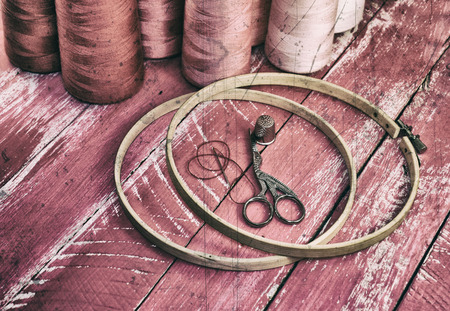 Stylized vintage photo of objects for needlework on a wooden pink backgroundの写真素材