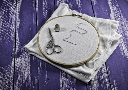 Vintage photos of items for embroidery, lying on a wooden table purple