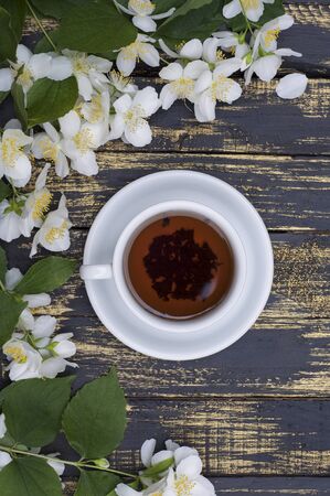 cup of jasmine tea with jasmine flowers on a tableの写真素材
