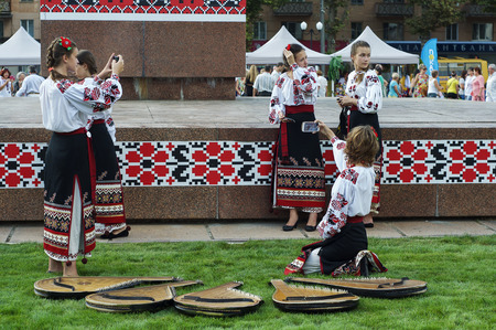 Young girl musicians in traditional Ukrainian clothes with embroidery make selfie on a mobile phone at the festival August 24, 2016 Day of Independence of Ukraine, Khersonのeditorial素材