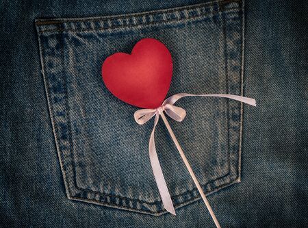 Wooden figure of heart on the background of the back pocket of blue jeans, full frame, vintage...