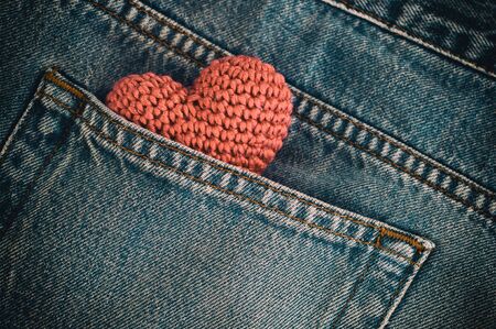 Small knitted heart in the back pocket of jeans, vintage toning