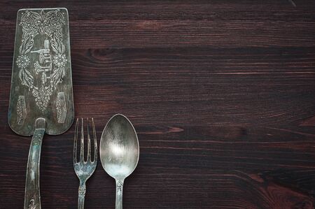 Vintage cutlery on brown wooden surface, top view, an empty space on the rightの写真素材