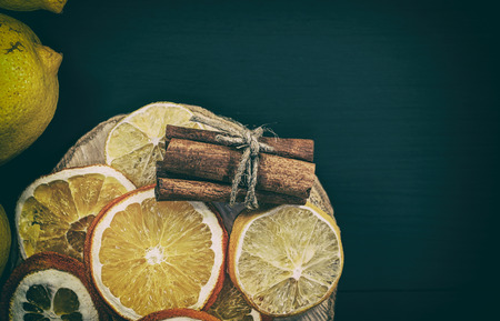 Citrus and cinnamon on the black wooden background,  view from above, vintage toningの写真素材