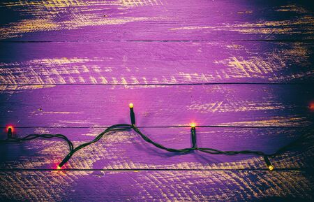 Lilac shabby wooden background with electric garland and burning lights, the empty spaceの写真素材