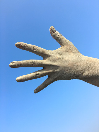 Women's human left hand in the splayed fingers of the hand in the dirt