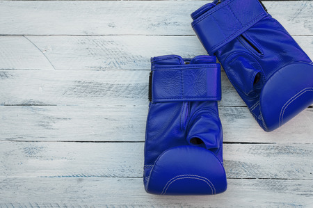pair of blue boxing gloves on a white wooden surface, empty spaceの写真素材