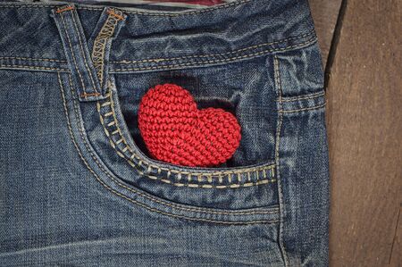 little knit heart in the front pocket of blue jeans, closeupの写真素材