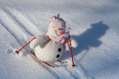Cloth Snowman on skis down a slope with snow, clear winter dayの写真素材