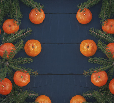 ripe tangerines on a black wooden surface, top view, vintage toningの写真素材