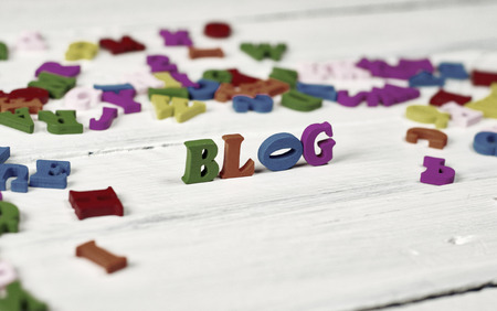 Colorful wooden letters on a white surface, the word blog