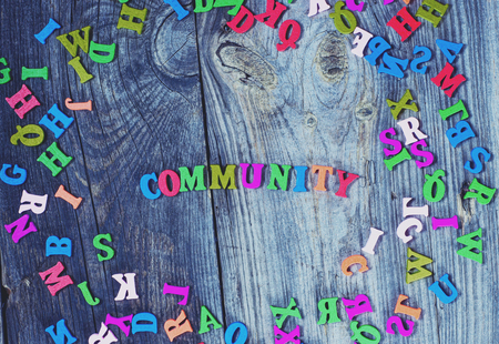 Colorful wooden letters on a gray old wooden background, in the middle of the word communityの写真素材