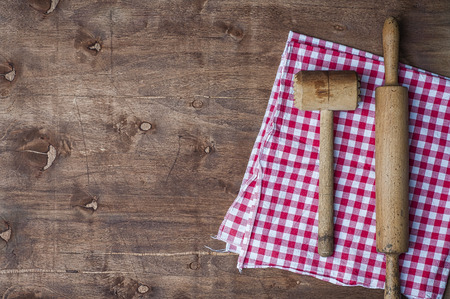 Wooden kitchen items on a red napkin, rolling pin and hammer for beating meat, top view, empty space on the leftの写真素材