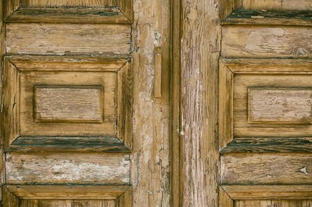 Fragment of a wooden brown old front door with a wooden handleの写真素材