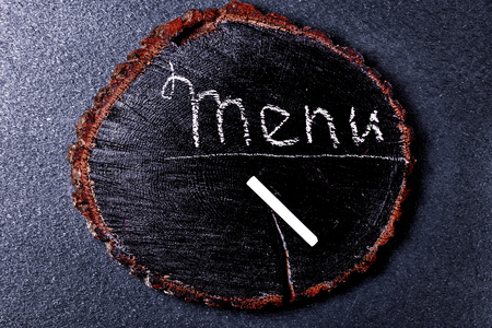 menu inscription in chalk on a wooden blackboard, top view, vintage toningの写真素材