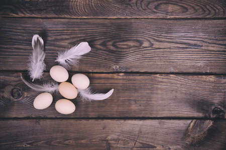 group of chicken eggs on brown wooden surface, empty space on the rightの写真素材