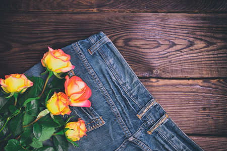 bouquet of fresh yellow roses lying on the blue jeans,  empty space, vintage toningの写真素材