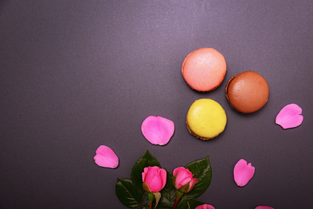 bouquet of  pink roses and three multicolored macaroons on a black backgroundの写真素材