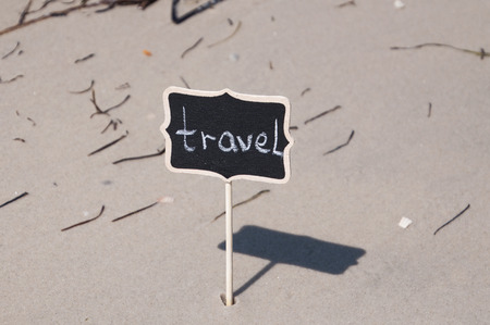 Black wooden board with inscription travel on the seashore, close upの写真素材