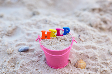 Word help from multicolored wooden letters in an iron pink bucket, top viewの写真素材