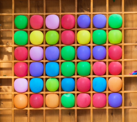 Multicolored inflated balls in wooden cellsの写真素材