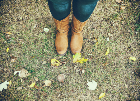 brown leather boots on female legs, top view, autumn day