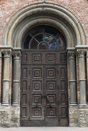 old wooden front door to a historic building of red bricksの写真素材