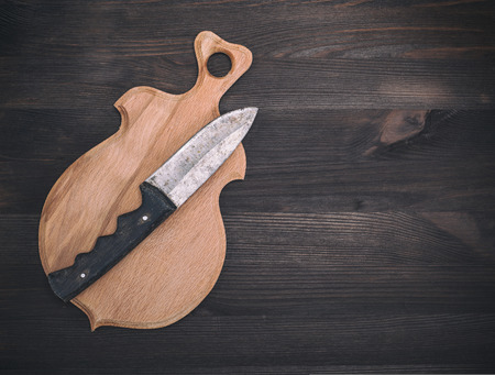 wooden cutting board and old knife on a brown wooden background, empty space on the rightの写真素材