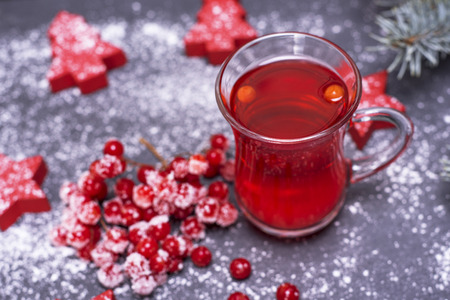 tea from fresh red viburnum in a transparent glass on a black background, near branch with red berries of viburnum in sugar, top viewの写真素材