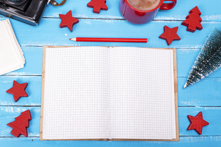 open blank notebook with a red pencil on a blue wooden background, top viewの写真素材