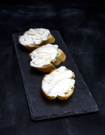 sandwiches with creamy white cheese on a black background, close upの写真素材