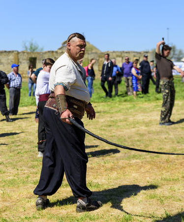 Kherson, Berislavsky district, Republicanets village, National park Kam'janska Sich , UKRAINE - APRIL 30, 2018:man dressed in traditional clothes of Ukrainian Cossacks with whipsのeditorial素材