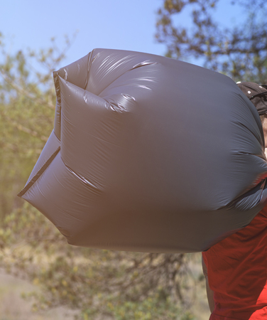full black plastic bag with garbage in human hands, close up