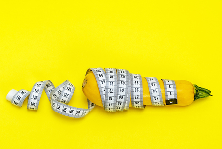 yellow zucchini wrapped in a measuring tape, weight loss conceptの写真素材