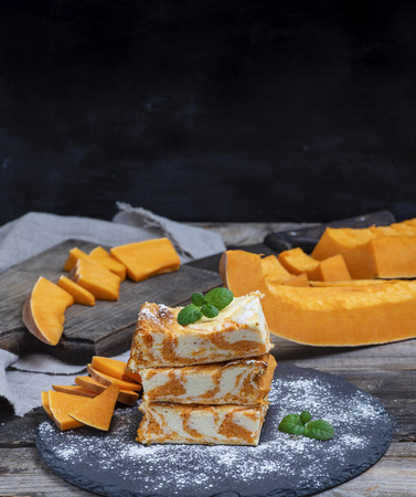 stack of square pieces of cottage cheese pie and fresh pumpkin, copy spaceの写真素材