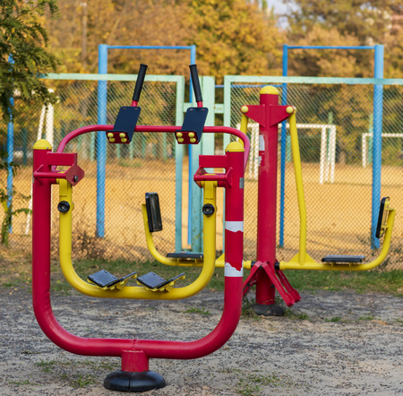red iron simulator for playing sports in a city public park, autumn dayの写真素材