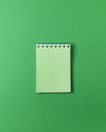open small empty notebook on a green background, top viewの写真素材